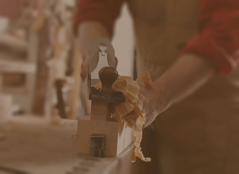 amish furniture builder working hand plane